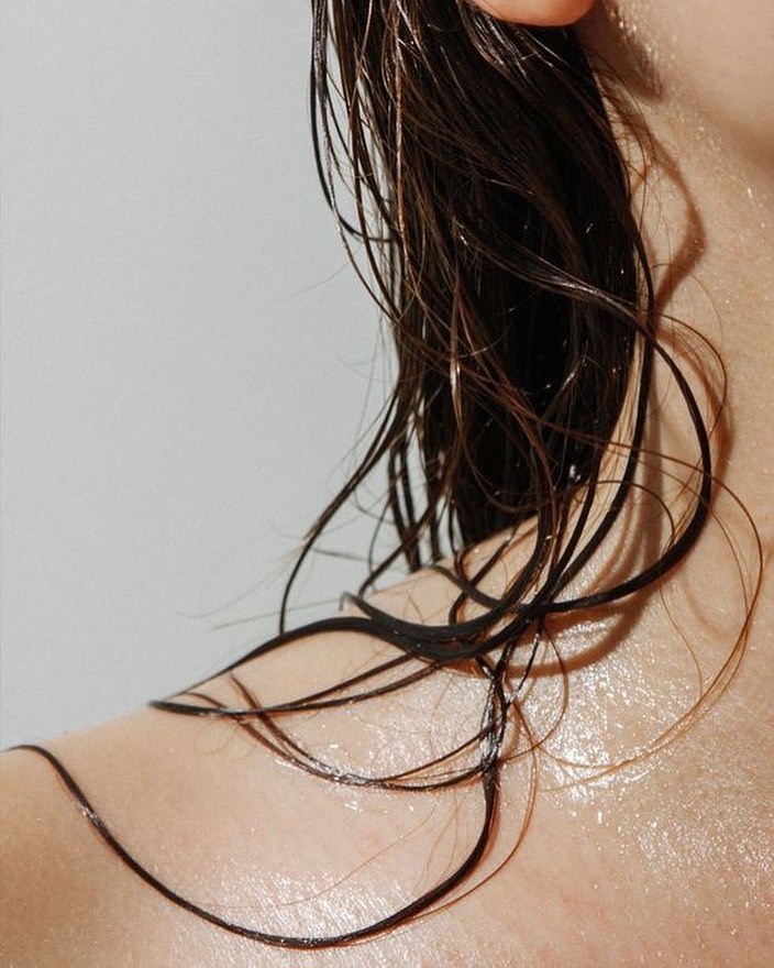 cropped image of woman with wet hair taking care of her scalp health for healthier hair