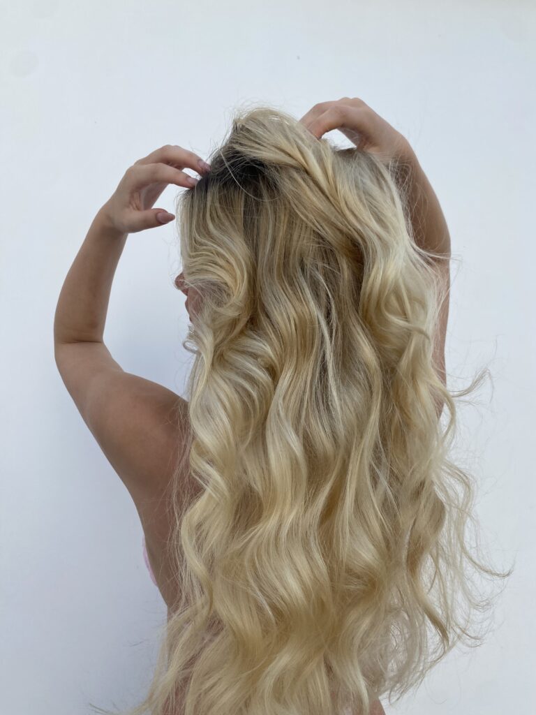 Woman with long blonde healthy hair due to proper scalp care